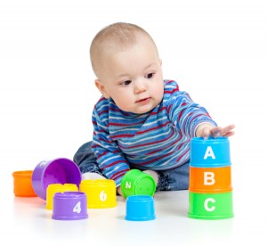 baby is playing with educational toys over white background